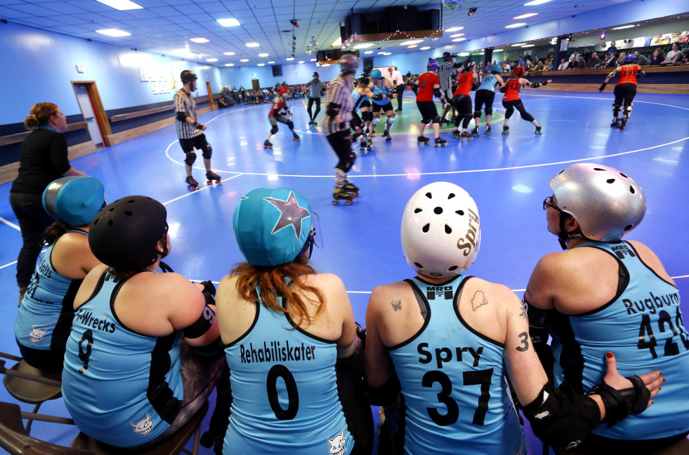 R.I.P. Tides teammates watch the action Saturday in their bout with the Calamity Janes at Happy Wheels in Portland.