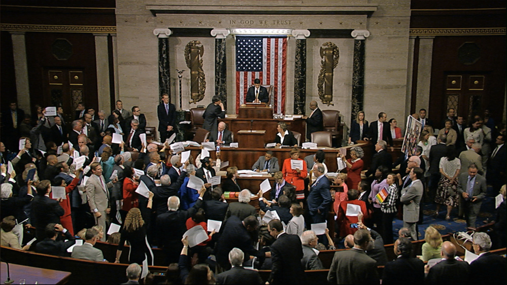 Angry Democrats shout "No bill, no break!" while waving pieces of paper with the names of gun victims as Speaker Paul Ryan tries to reconvene the House on Wednesday night. After Ryan tried to ignore the outbursts, Democrats began singing "We Shall Overcome."
