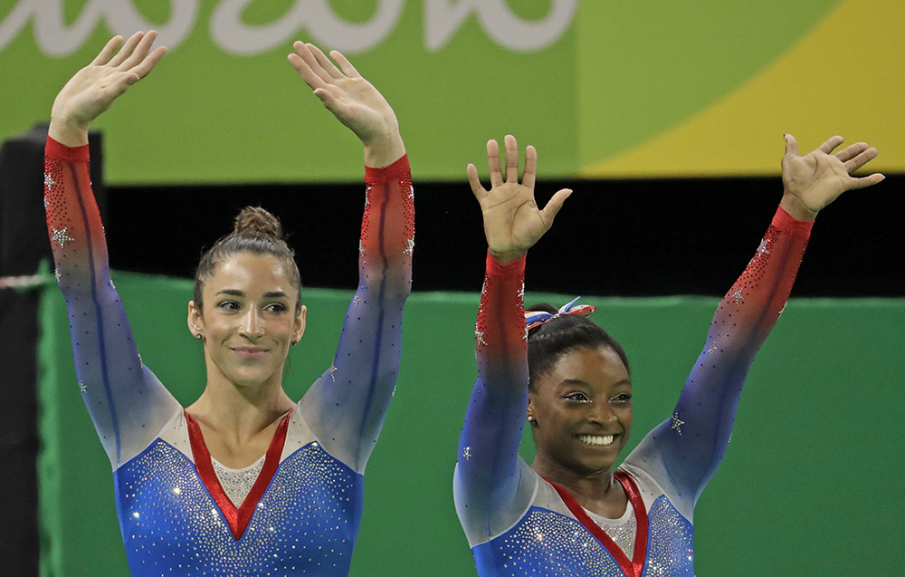 Simone Biles, gold medal winner, and silver medallist and compatriot Aly Raisman, left, wave after final results for floor routine during the artistic gymnastics women's apparatus final at the 2016 Summer Olympics in Rio de Janeiro Tuesday. Dmitri Lovetsky/Associated Press
