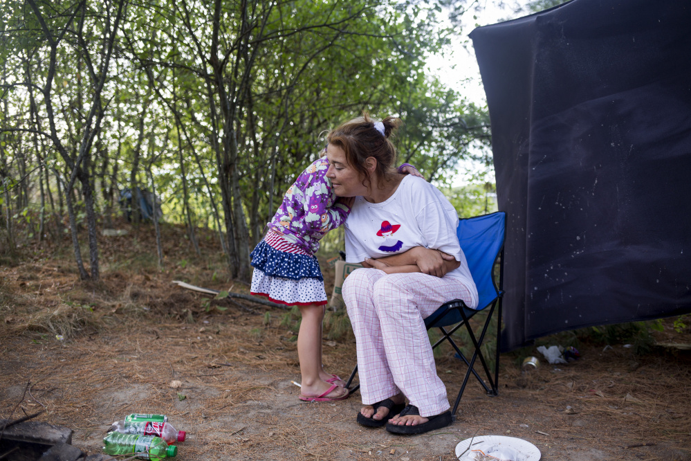 Arianna hugs Chrissy for warmth on a chilly morning at the Portland campsite known as Tent City.