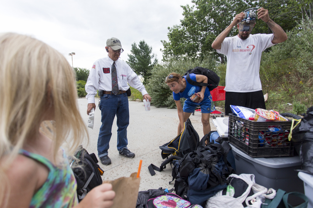 From left, Arianna, Roger Goodoak, Chrissy and Troy bring the family's belongings out of the woods and into the Lowe's parking lot to load into Goodoak's van for their move up to the Lewiston/Auburn area. Goodoak runs a small nonprofit that helps homeless people. He has been helping Troy, Chrissy and Arianna since he saw Troy panhandling near Lowe's. Troy got a call the night before from a state social worker who said he'd found a landlord in Lewiston who would accept their housing voucher and that they could move into an apartment.