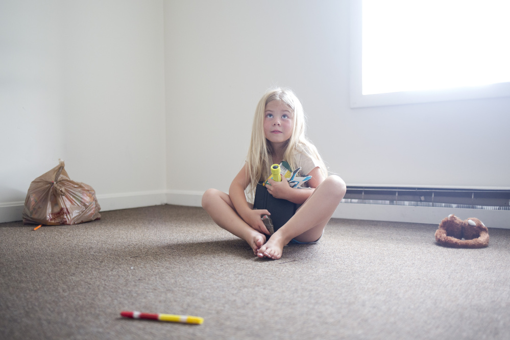 Arianna unpacks her toys in her new bedroom.