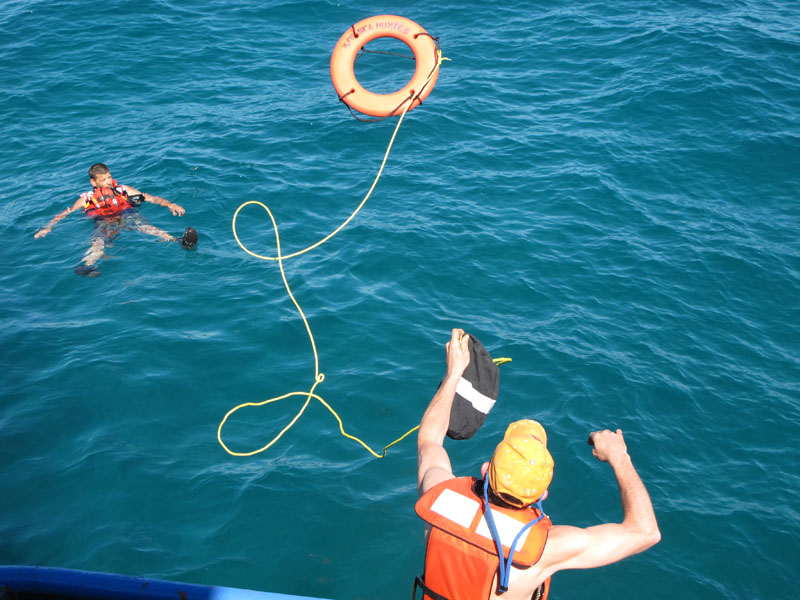 Sea Hunter deckhand Alex Bezkorovainy throws a life ring to volunteer Rick Woodbury of Scarborough during a safety drill on Saturday off Miami.