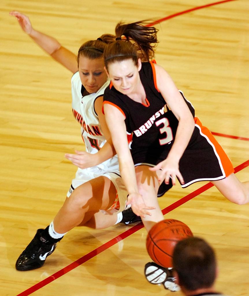 Staff photo by Joe Phelan Skowhegan sophomore guard Amanda Johnson, left, and Brunswick senior guard Hilary Champagne chase a loose ball during the Eastern Maine Class A regional girls basketball championship Friday at the Augusta Civic Center. Skowhegan won 38-36.