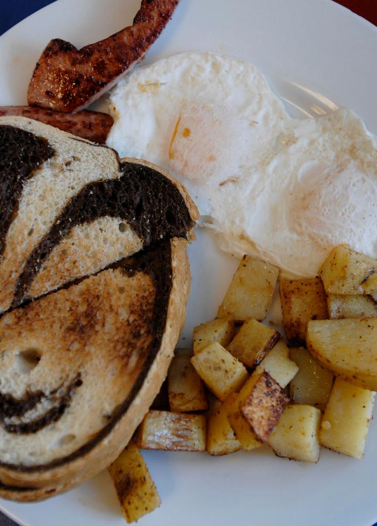 Over-easy eggs with kielbasa and home fries with marble rye toast at Uncle Andy's in Portland .