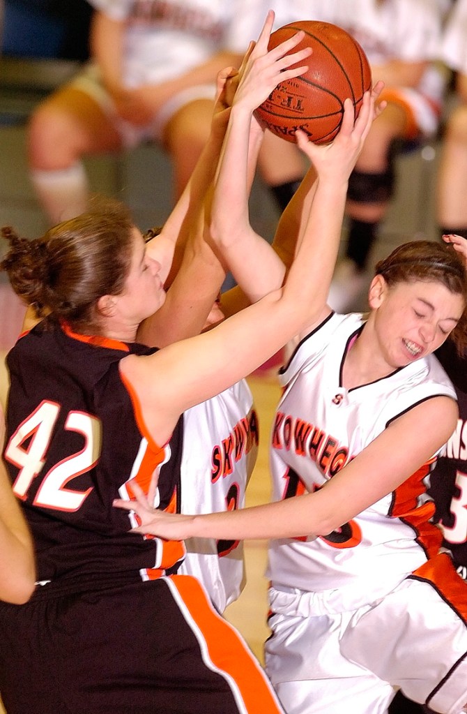 Lydia Caputi, left, of Brunswick battles with Skowhegan’s Jaimi Poland, center, and Adrienne Davis during the Eastern Class A championship game at the Augusta Civic Center. Skowhegan won, 38-36.