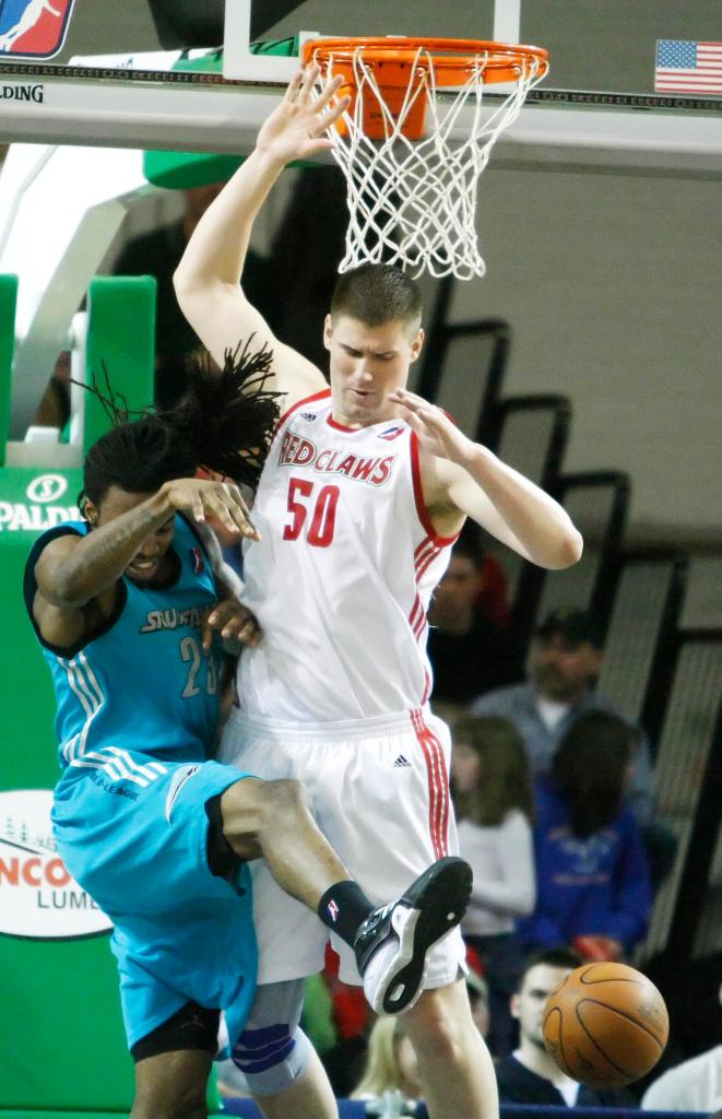 The ball slips away as Maine’s Paul Davis, right, and Raymond Sykes of Sioux Falls battle for a rebound Sunday night at the Portland Expo. Sioux Falls won, 99-98.