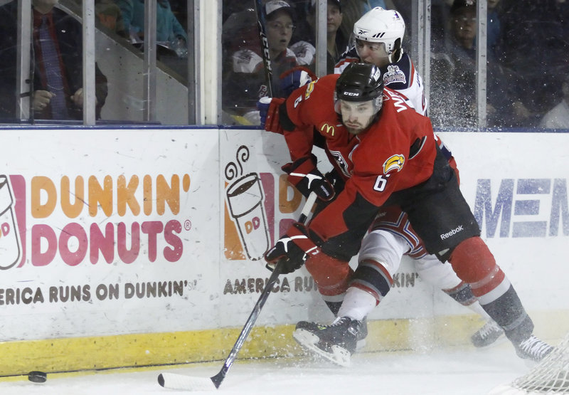 Pirates defenseman Mike Weber pins Hartford's Paul Crowder along the boards during Sunday's game. Weber also scored his fifth goal of the season.