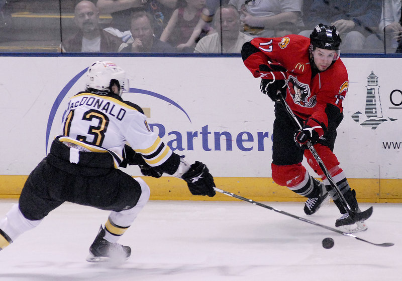 Marc-Andre Gragnani of the Pirates makes a pass under pressure from Providence's Kirk MacDonald during Sunday's game at the Civic Center. Providence won in overtime, 3-2.