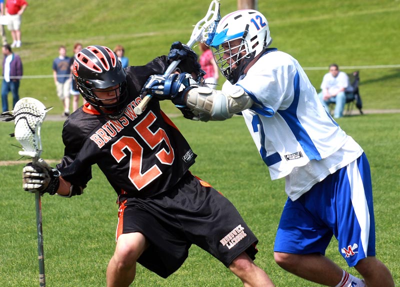 Jacob Erskine, right, of Messalonskee delivers a hit to Zach McMillan of Brunswick during the first half of their schoolboy lacrosse game Saturday at Oakland. Brunswick won, 9-5.