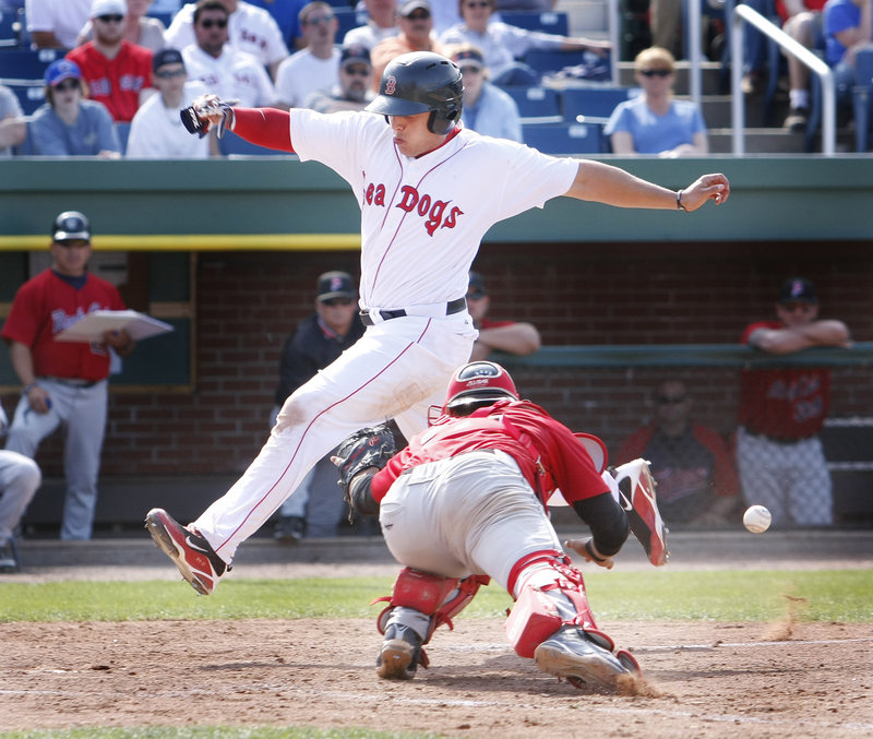 Luis Exposito beats the throw to the plate and lunges past New Britain catcher Alexander Soto to score on a sacrifice fly by Yamaico Navarro during the Sea Dogs' 4-1 win.