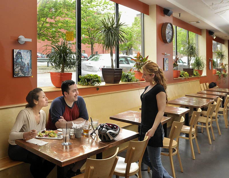 Paige Vashon, a server at Nosh Kitchen Bar, asks customers Luisa Barragan and Jonathan Koerber how their meal tastes after they stopped in for a quick lunch while bike touring in Portland.