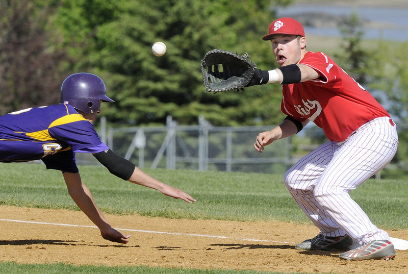 Louis DiStasio of Cheverus dives safely back to first, just ahead of the throw to South Portland's Zack Horton. The Riots won 4-3 Thursday. Both teams are now 6-2.