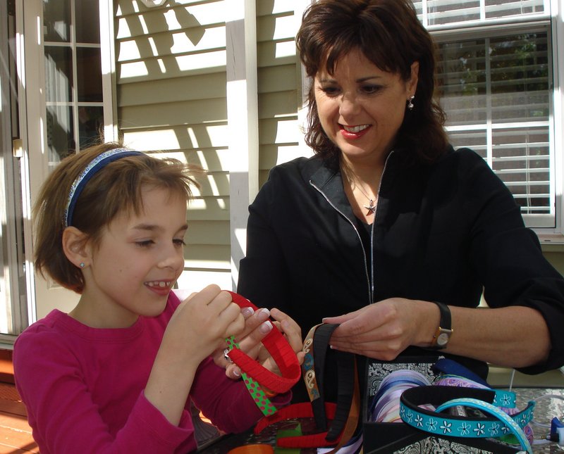 Caroline Davis works with her mother, Robin Desjardins-Davis, to pair patterns with solid color ribbon to adorn the plastic headbands being sold to benefit the Alzheimer's Association, Maine Chapter, and the Cancer Community Center.