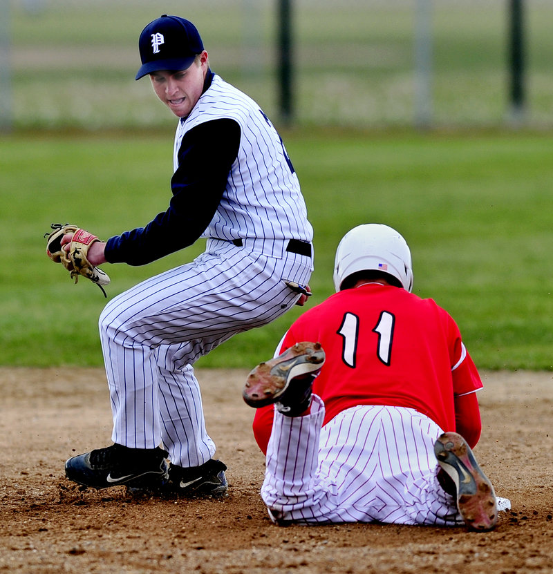 Ben DiBiase of Portland High snares a wide throw as South Portland’s Evan Imdorf steals second with a headfirst slide in Tuesday’s game at South Portland. The Red Riots posted a 2-0 victory.