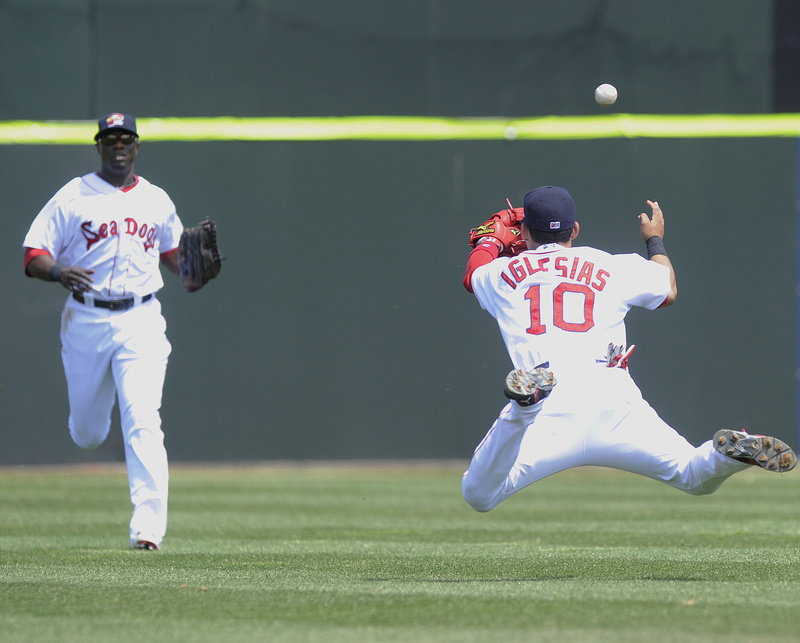 With rehabbing Red Sox center fielder Mike Cameron racing in, Sea Dogs shortstop Jose Iglesias can’t quite reach a pop fly with a diving try during Thursday’s game at Hadlock Field. Cameron was 1 for 4 in his first appearance with Portland, and New Britain won, 6-2.