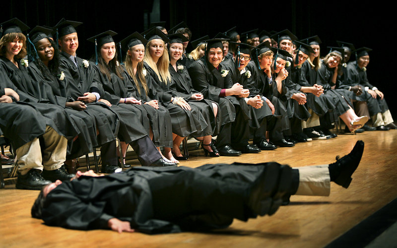 Kai Patricio and Donald Bennett perform the "Feets of Strength" during Principal Derek Pierce's remarks to the Casco Bay High School class of 2010 at Merrill Auditorium in Portland. Pierce asked them to hold their legs in the air to show the tenacity, will power and determination the graduates displayed in order to accomplish their goals.