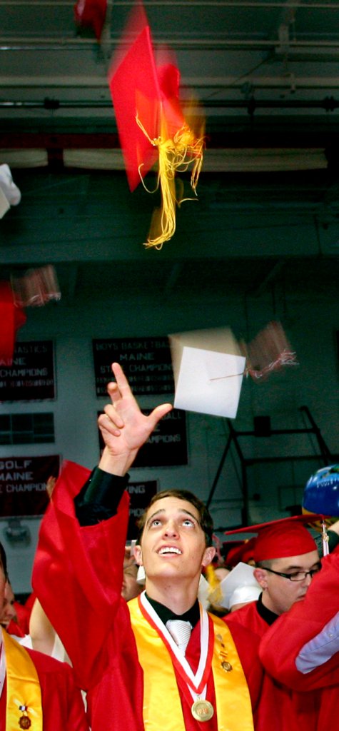 Sam Ouellette tosses his mortarboard in the air at the conclusion of the South Portland High School graduation on Sunday.