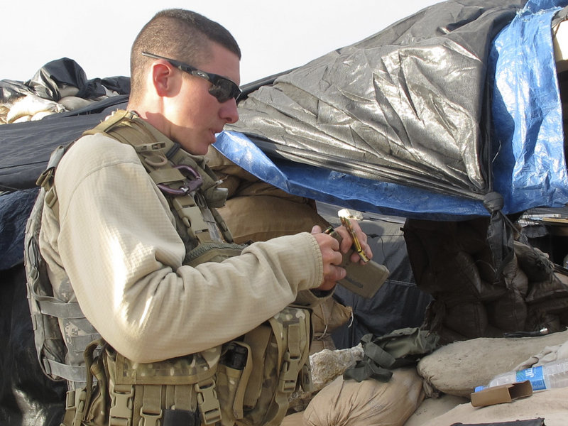 Pfc. Dereck Bourque of Sanford loads a magazine for his M-4 rifle Sunday evening at the observation post manned by Bravo Company, 3rd Battalion, 172nd Infantry.