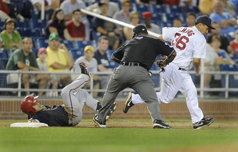 Umpire Doug Vines calls out Harrisburg's Jhonatan Solano after a tag by Portland third baseman Ray Chang on Monday night at Hadlock Field. Solano tried to take third base after his RBI double in the sixth inning.