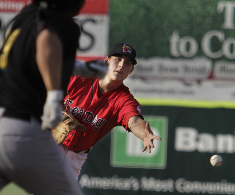 Portland's Anthony Rizzo flips the ball to first base in time to get the runner out after fielding a ground ball in the second inning against the New Hampshire Fisher Cats on Monday night at Hadlock Field. A sell-out crowd of 7,368 watched the Dogs fall short.