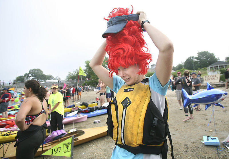 Kara Wooldrik adjusts a visor on her beehive wig before steering a kayak as the spotter for Liz McGee in the Peaks to Portland swim. The wig made Wooldrik easier to see.