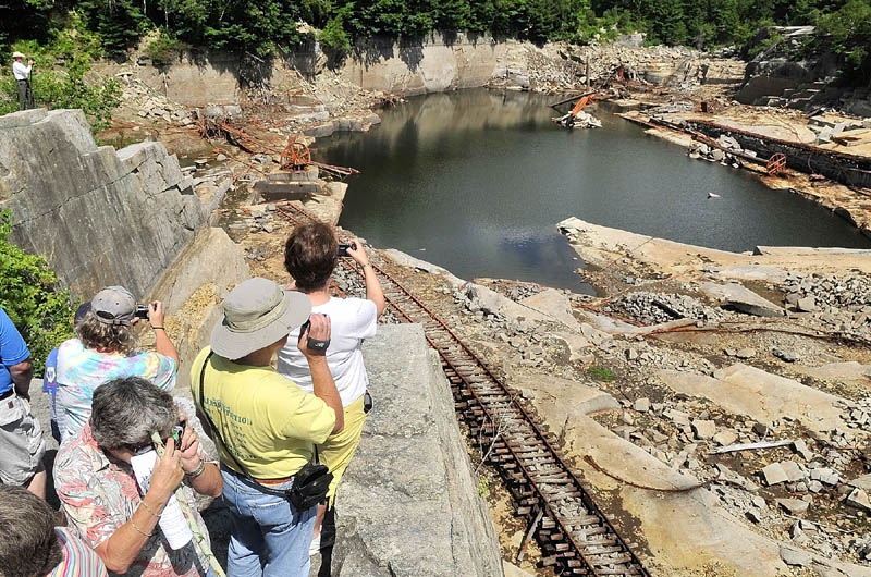 People snap pictures from the cliffs high above the Stinchfield Quarry during a tour on Sunday afternoon in Hallowell.