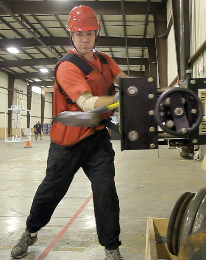 Reporter Matt Wickenheiser uses a sledgehammer at one of the nine legs of the Candidate Physical Ability Test at a warehouse in Portland on Wednesday. The Portland Fire Department uses the CPAT to assess potential firefighters.