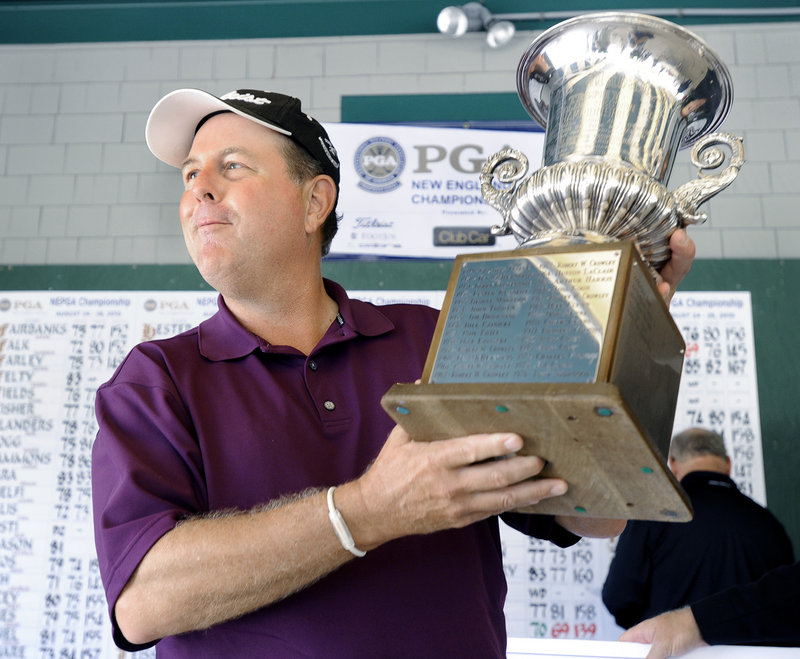 Scott Spence hoists the winner's trophy after shooting a 69 to win the title with a two-round total of 139.