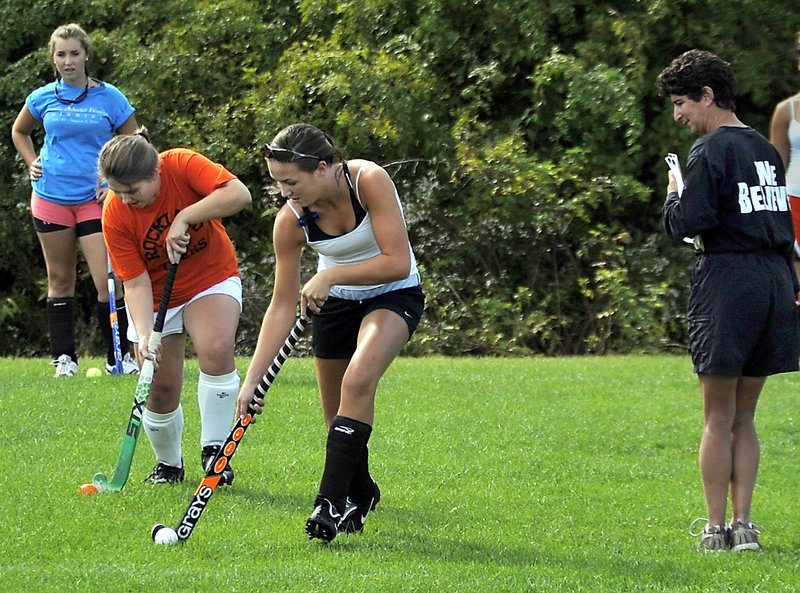 Joanna Hall, the coach, right, has had to learn about new players, but the team says she’s been fair. Practicing are Madison Sturks, rear, Danielle Bedard and Hannah Plourde.