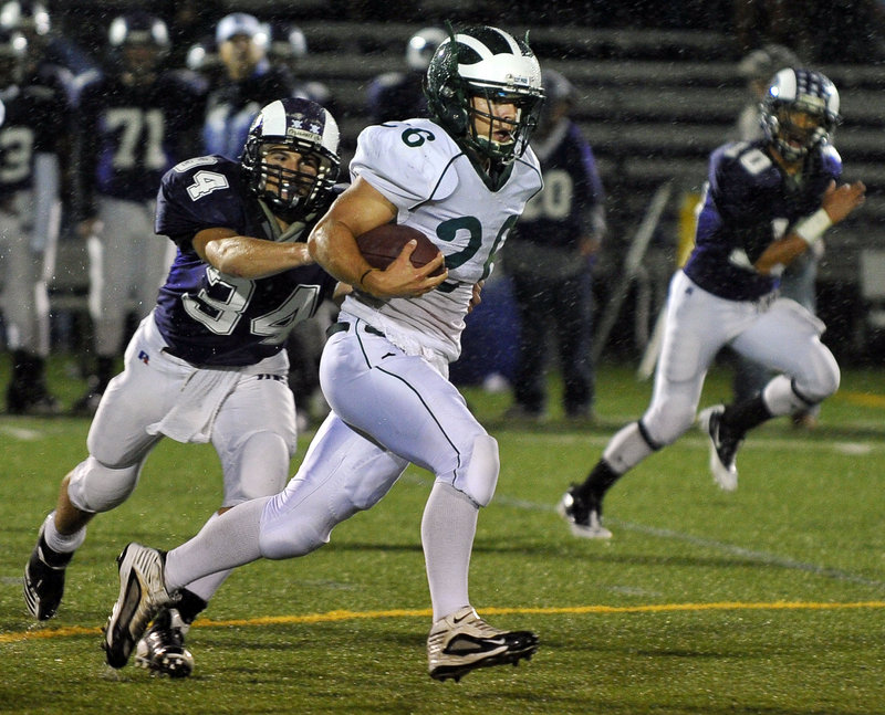 Ethan Thorne breaks away from Deering’s Kenny Sweet on his way to a big gain. Thorne had one of five rushing touchdowns for Bonny Eagle.