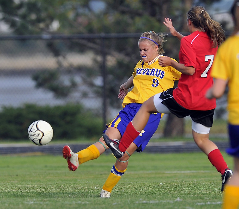 Allison Thomas, left, of Cheverus sends a shot past Sarah Martens of Scarborough during an SMAA girls’ soccer game Thursday. Scarborough won the matchup of unbeaten teams, improving to 6-0 with a 2-0 victory, scoring twice in the first half.