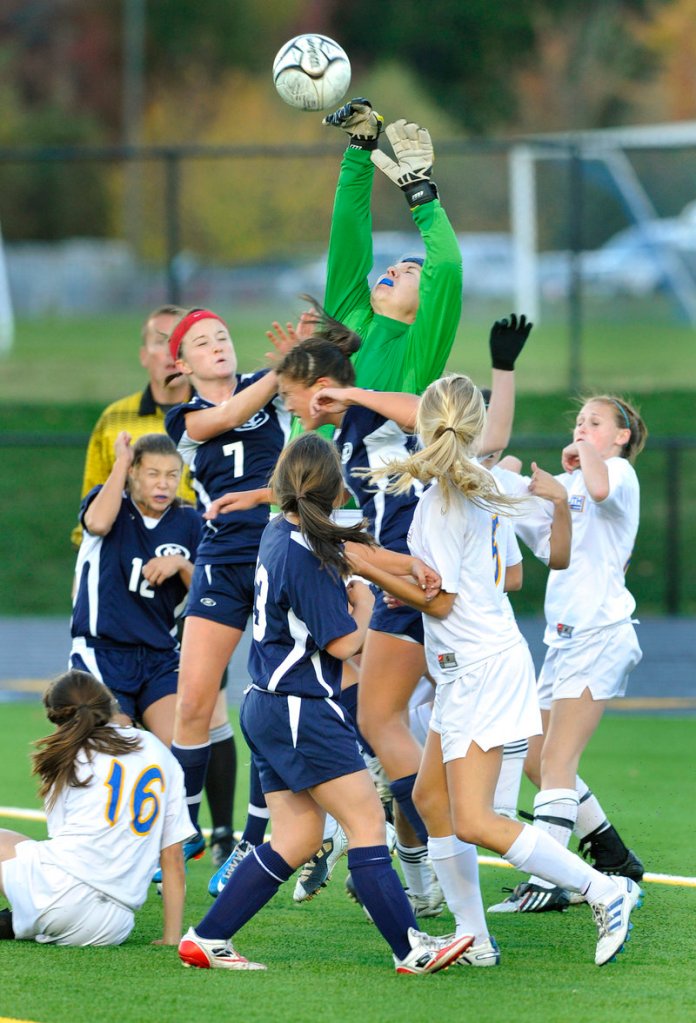 Falmouth goalie Elizabeth Estabrook takes command Tuesday, batting the ball away on a corner kick as Yarmouth players converge, including Rebecca Bell, 7, and Jeanna Lowery, 12. The game finished scoreless.