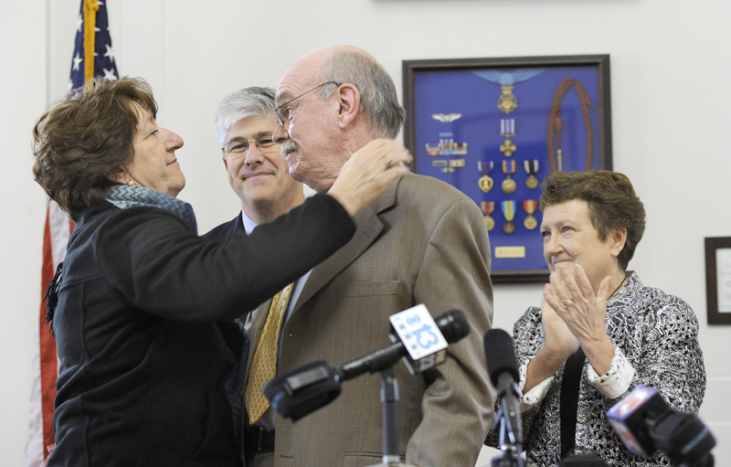 Councilor Cheryl Leeman hugs Portland City Manager Joseph Gray as Mayor Nick Mavadones and Gray's wife, Marie, look on. Gray announced Tuesday that he will retire in February.