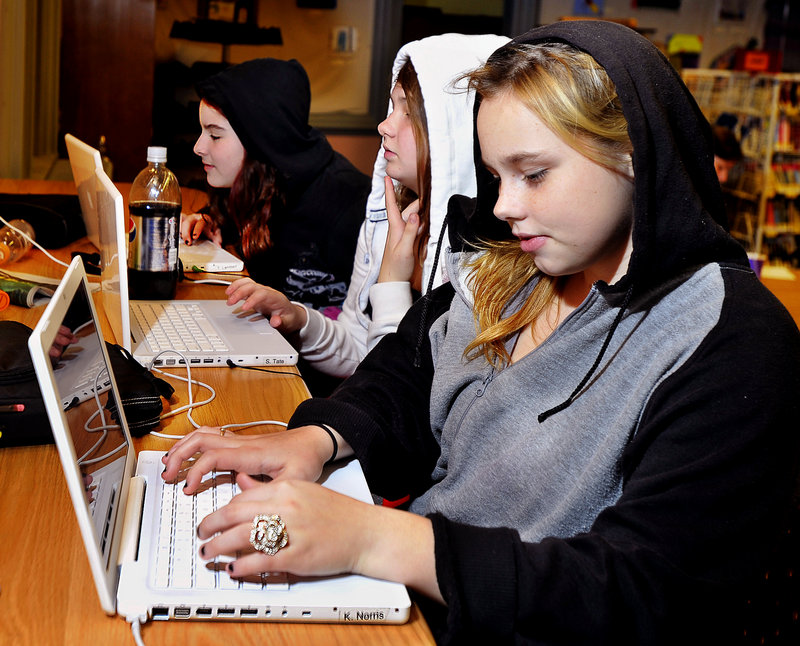 From left, Taylor Lambert, 12, Samantha Tate, 13, and Kori Norris, 13, update their Facebook pages using the free wireless service in McArthur Library’s new teen space.