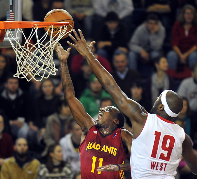 Fort Wayne’s Walker Russell Jr. goes up for a layup in the first quarter Friday night, but Mario West blocks it to the delight of another sold-out crowd at the Portland Expo. West led the Red Claws with 19 points.