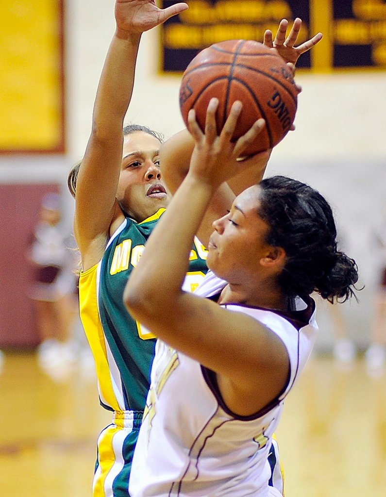 Meghan Agger, who scored 12 of the 21 points Wednesday night for Thornton Academy, looks for room against tight defense applied by Allie Clement of McAuley during their Western Class A game at Saco.