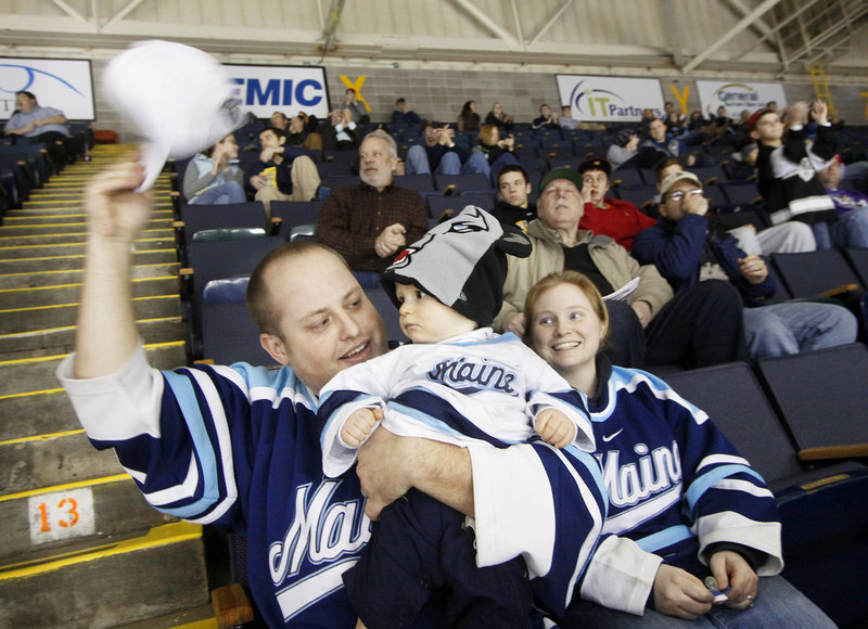 Josh Shorey of Hermon celebrates a Black Bear goal with his wife, Melissa, and son, Benjamin, 9 months, wearing his Bears hat, during an exhibition hockey game between the University of Maine and the under-18 U.S. national team Sunday at the Cumberland County Civic Center in Portland.