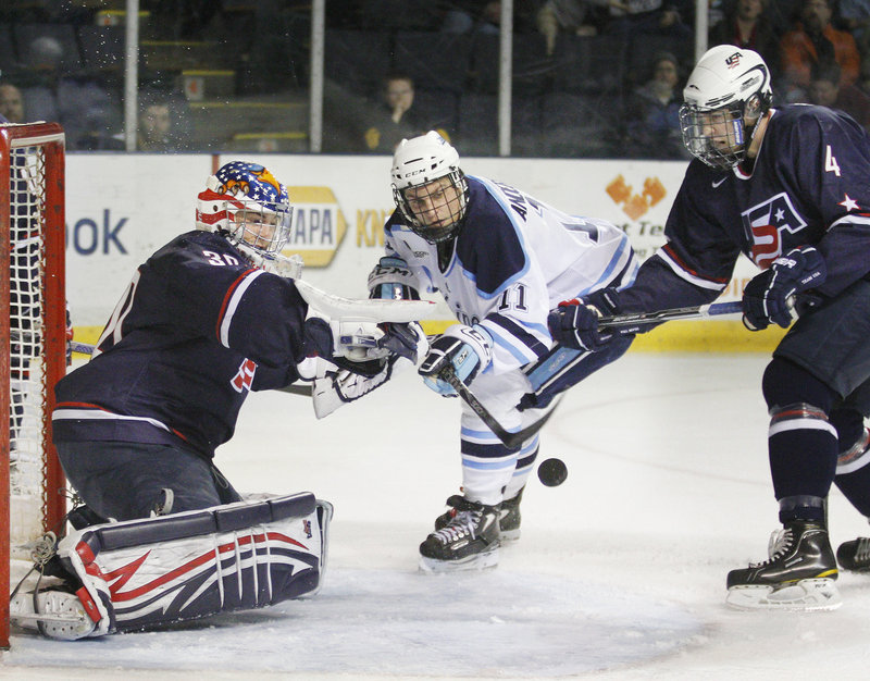 UMaine's Theo Andersson gets a shot off against U.S. goalie Matt McNeely, left, as defenseman Michael Pailotta closes in on Sunday.