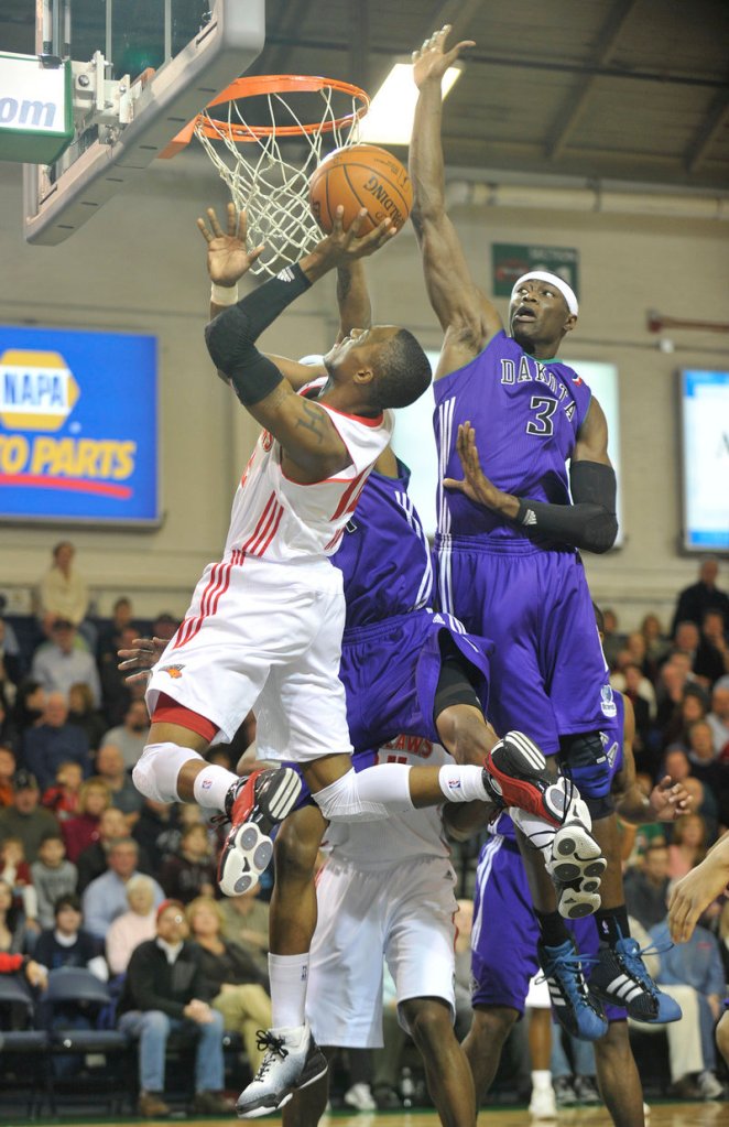 Kenny Hayes of the Maine Red Claws takes the ball to the basket Friday night as Hamady N Diaye of the Dakota Wizards, right, attempts to swat it away. Dakota won, 93-70.