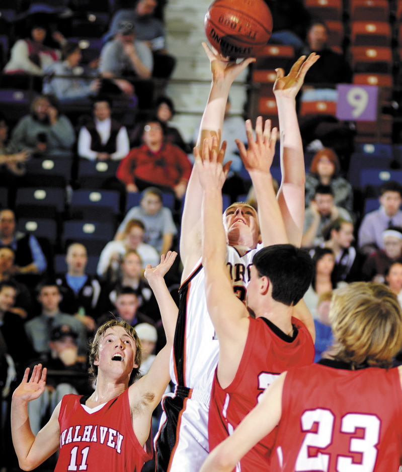 Raymond Petrin, center, of Forest Hills goes up for a shot between Vinalhaven's William Drury, left, John Morton, far right, and Scott James. Vinalhaven advanced to the Western Class D final with a 53-44 victory.