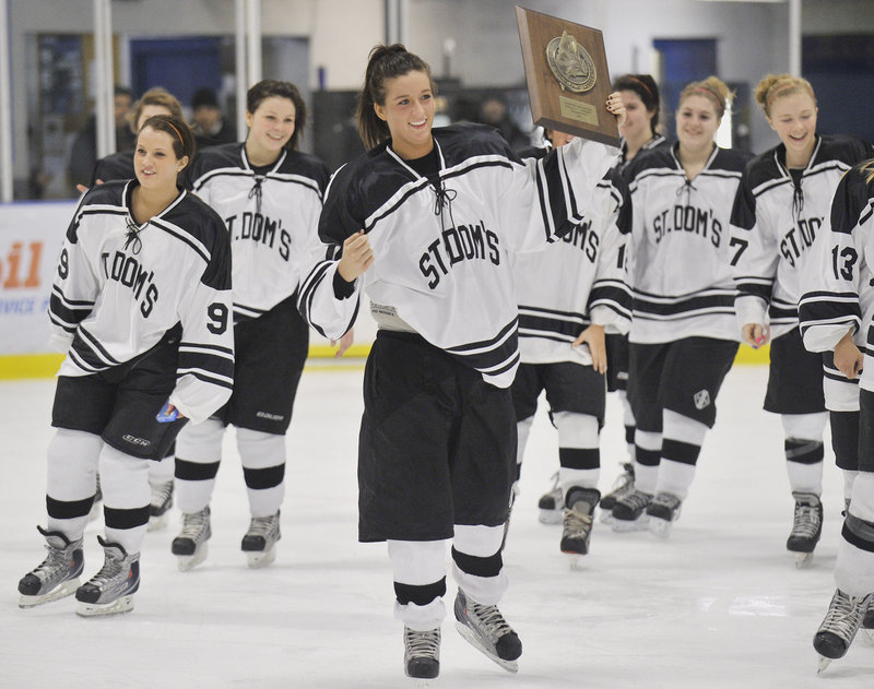 Sophie Goulet holds up the regional trophy Wednesday night after St. Dom's beat Greely 3-2 in the Eastern Maine final.