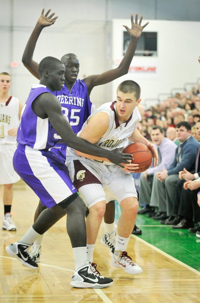 Andrew Shaw of Thornton Academy, who found little room to shoot Saturday night against Deering's defense, attempts to avoid being hemmed in by Thiwat Thiwat, left, and Labson Abwoch. Deering advanced, 41-33.