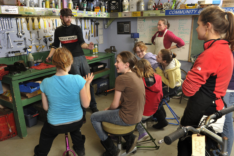 Chris Porter, a bicycle mechanic at Cycle Mania in Portland and the instructor for the girls-only Bike Monkeys course, discusses the evening s agenda with the students and their volunteer helpers.