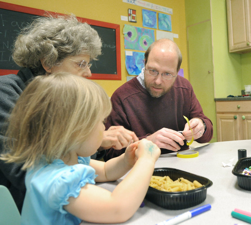 Reporter Ray Routhier creates noisemakers with Ginny Grabowski and her granddaughter, Gianna Grabowski, 3,