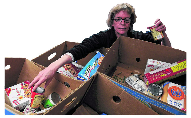 Volunteer Maureen Millette of Portland fills boxes at the York County Shelter Programs' Food Pantry in Alfred Friday.