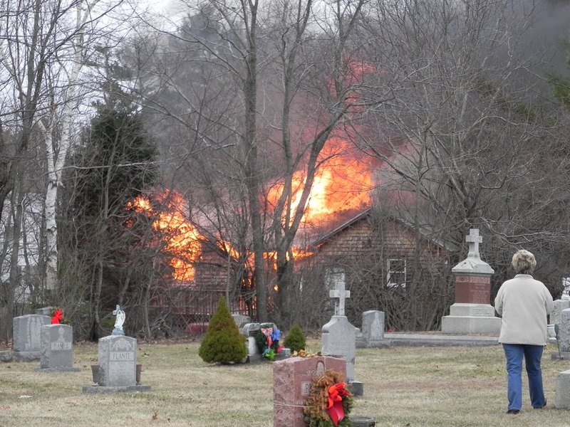 Flames leap from the roof of a home on Granite Street Extension in Biddeford after a plane crashed into it Sunday.