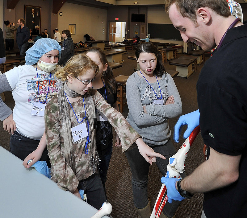 Zoe Gonzalez, 10, asks a question of UNE first-year medical student Eric Dombroski, right. Looking on are Sierra Boucher, 10, Reganne Fox and Alicia Roy, both 11.