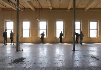 People on a tour look at an area in the Lincoln Mill with views of Main Street in Biddeford in this 2011 photo. Press Herald file