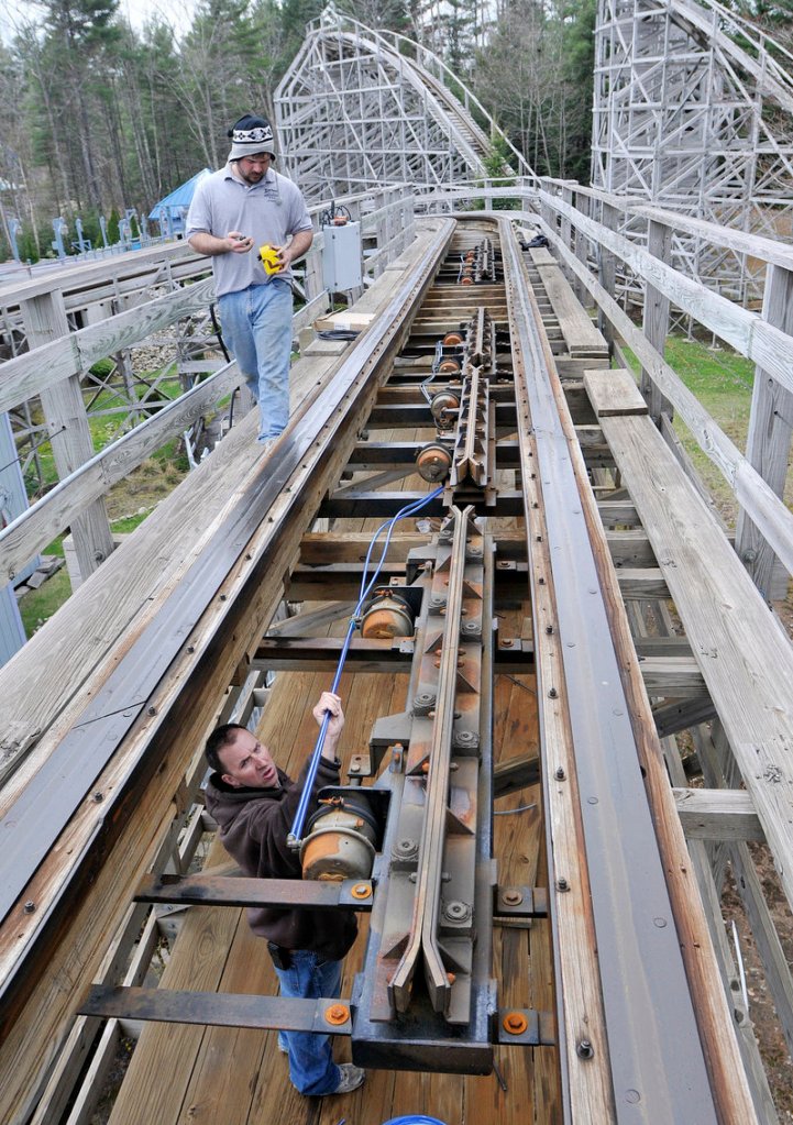 Cory Cormier, top, and Shawn Lariviere inspect and maintain the wooder rollercoaster Excalibur asFuntown/Splashtown USA gets ready for the season.